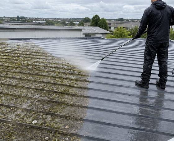 A commercial roof being soft washed