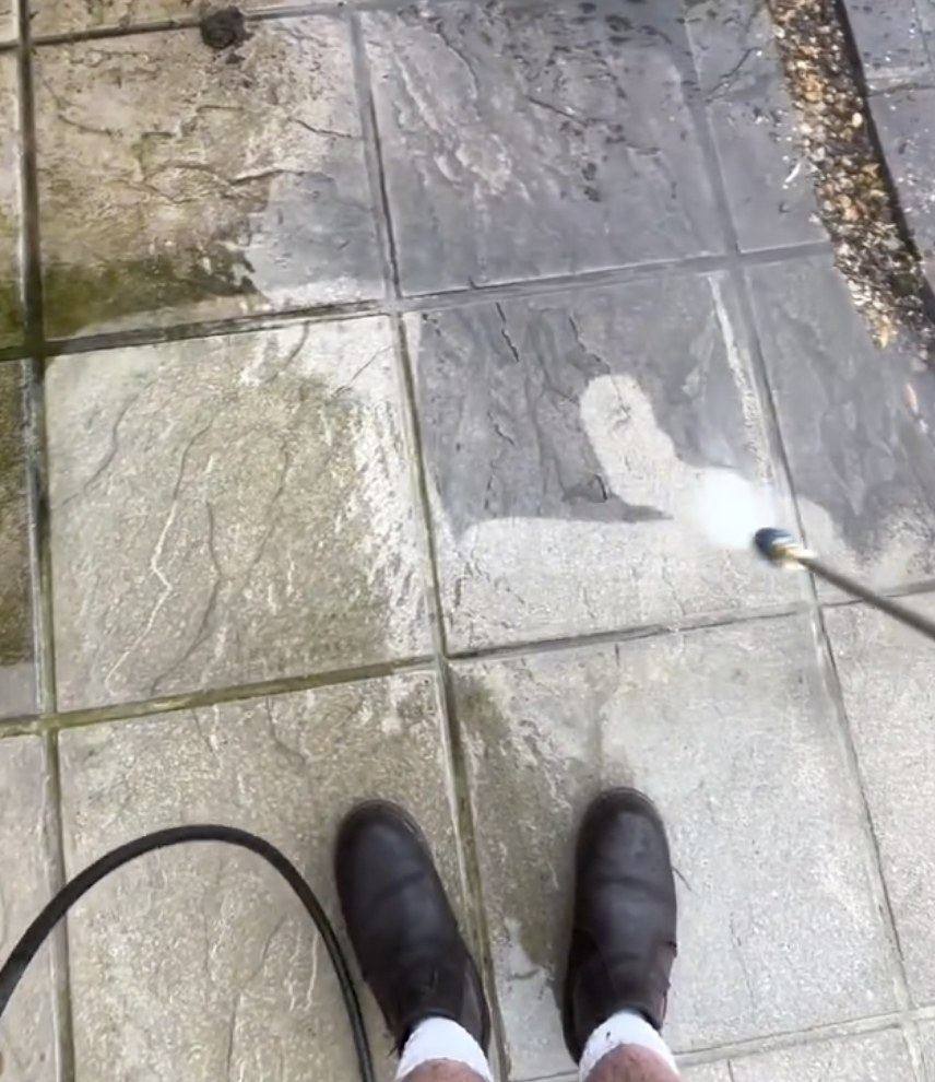 Grey paving slabs being pressure washed clean