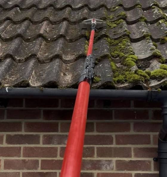A roof being cleaned with a telescopic lance